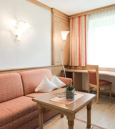 Hotel Sonklarhof in Hochgurgl – Wohnbereich mit Sofa und Schreibtisch im Hotelzimmer | Wellnesshotel Tirol