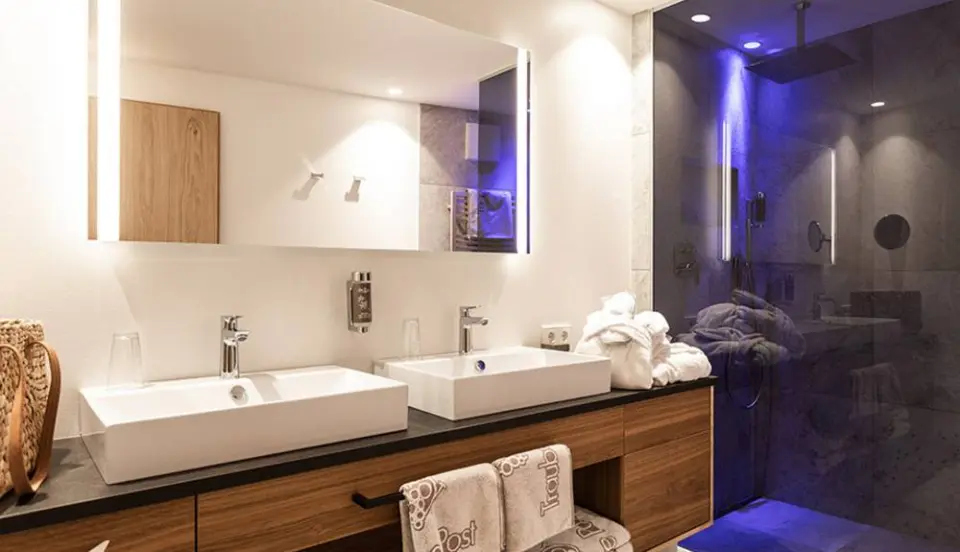 Hotel Traube Post am Reschensee in Reschen – Elegantes Badezimmer mit Doppelwaschbecken und Regendusche | Wellnesshotel Vinschgau