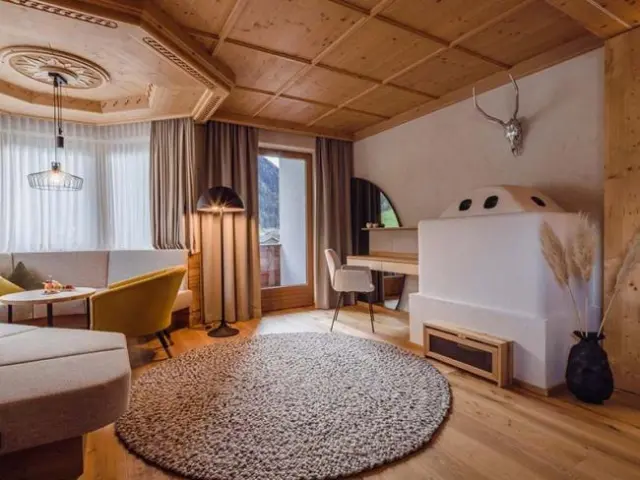 Relais & Châteaux Spa Hotel Jagdhof in Neustift im Stubaital – Geräumiger Wohnbereich einer Suite mit Kachelofen | Wellnesshotel Stubaital