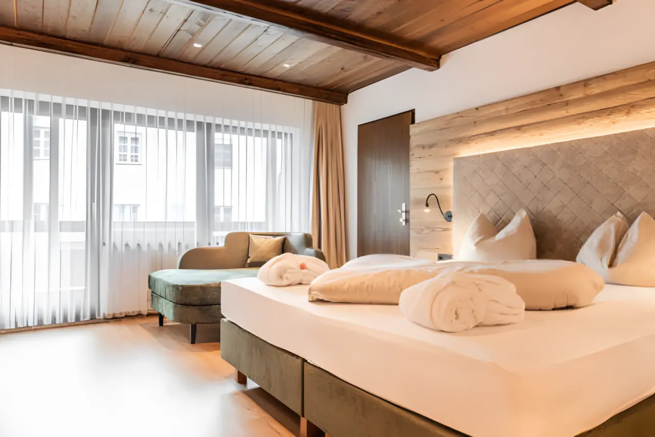Alpenlove - Adult Spa Hotel in Seefeld – Helles Doppelzimmer mit großem Fenster und Sitzgelegenheit | Wellnesshotel Tirol