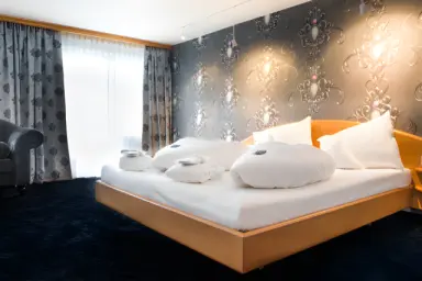 Alpenlove - Adult Spa Hotel in Seefeld – Komfortables Doppelzimmer mit gemusterter Tapete | Wellnesshotel Tirol