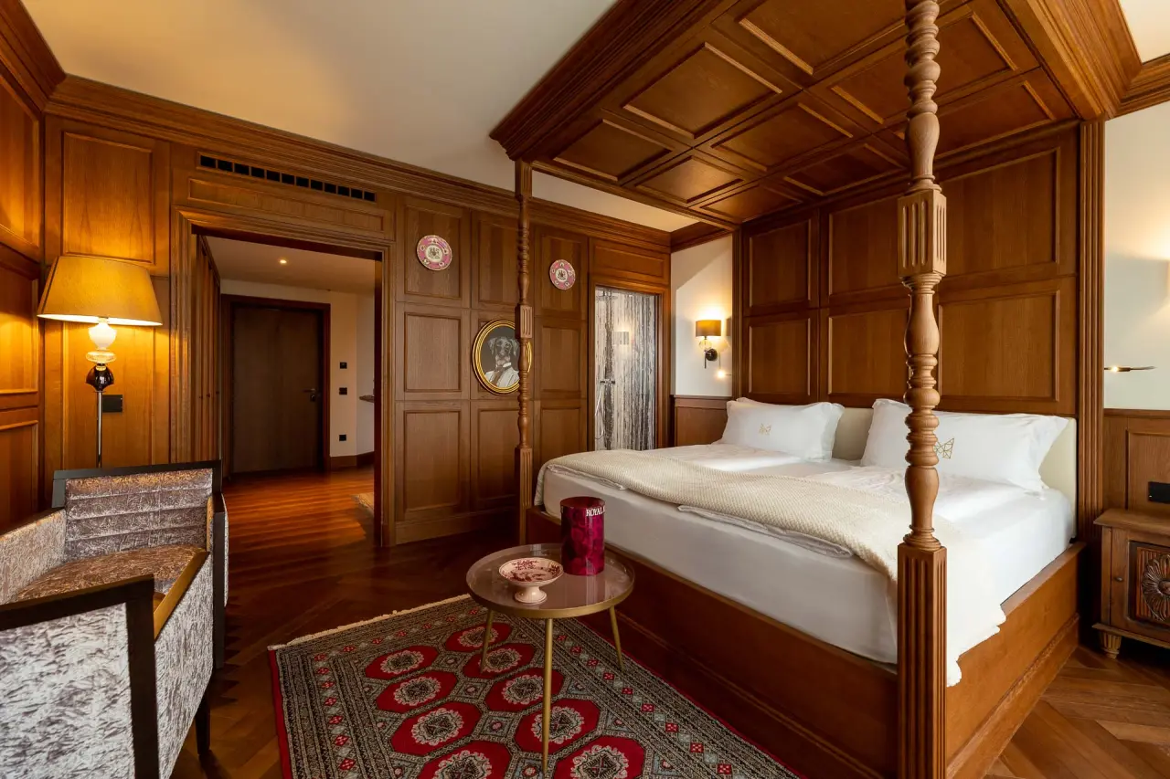 Manna Resort in Bozen – Elegantes Hotelzimmer mit Himmelbett und Holzvertäfelung | Wellnesshotel Südtirol