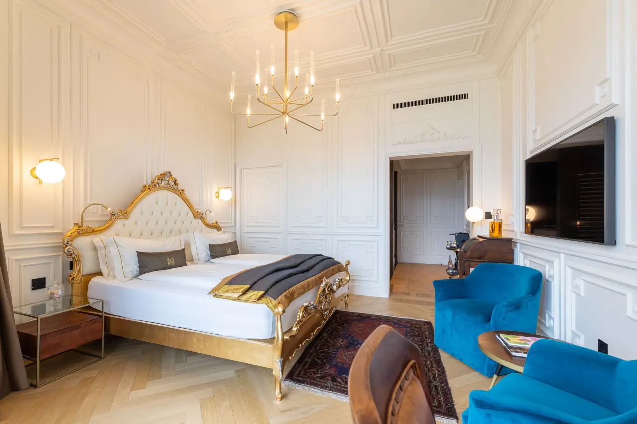 Manna Resort in Bozen – Elegantes Luxuszimmer mit goldenem Bett und Stuckdecke | Wellnesshotel Südtirol