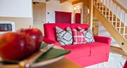 Beauty & Vital Hotel Maria in Cavalese – Gemütlicher Wohnbereich mit rotem Sofa | Wellnesshotel Trentino