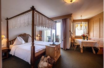 Hotel Finkennest in Schenna – Gemütliches Zimmer mit Himmelbett und Sitzecke | Wellnesshotel Südtirol