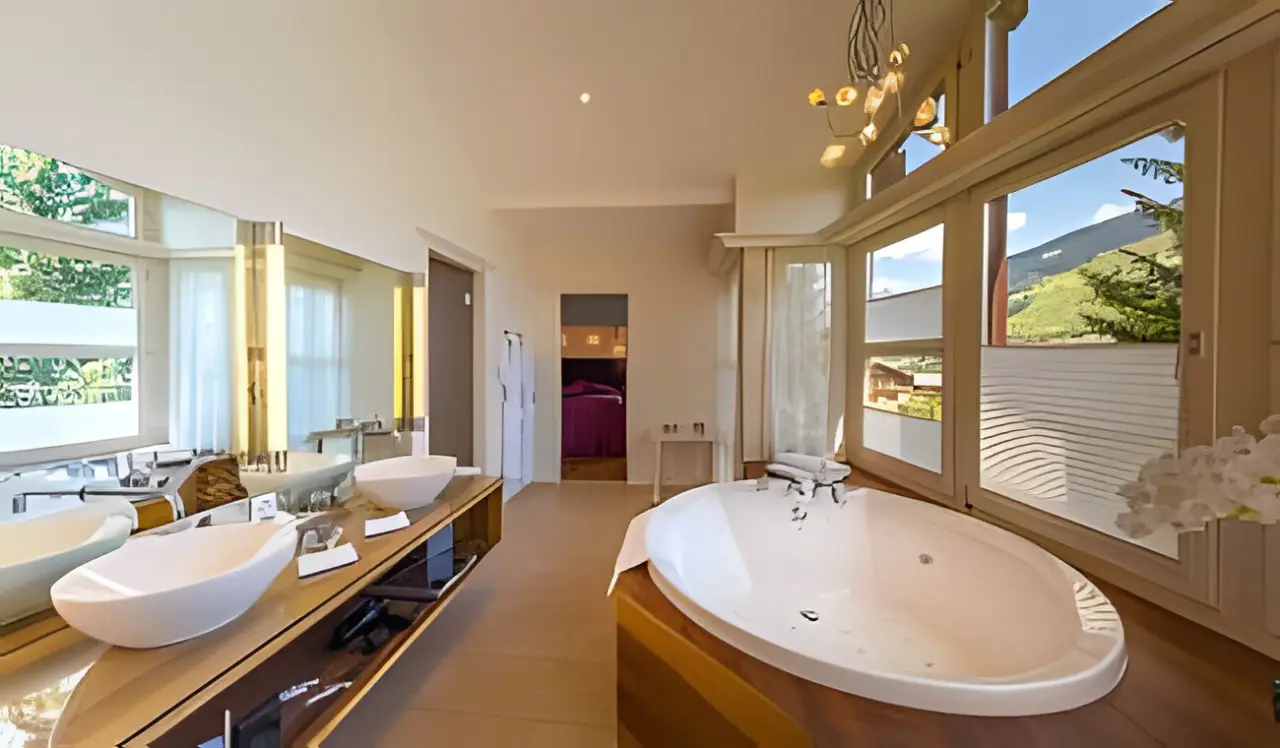 Lenkerhof gourmet spa resort in Adelboden – Luxuriöses Badezimmer mit Badewanne und Bergblick | Wellnesshotel Berner Oberland