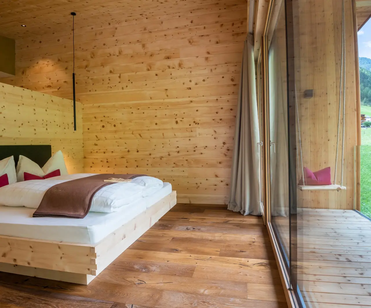 Naturhotel Rainer in Ratschings – Komfortables Zimmer mit Holzwänden und Schaukel | Wellnesshotel Südtirol