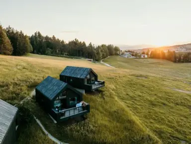 Green Luxury Hotel Pfösl in Welschnofen – Luxuriöse Chalets in den Bergen bei Sonnenuntergang | Wellnesshotel Südtirol