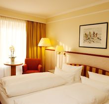 Fuchsbau Romantik Hotel in Timmendorfer Strand – Klassisches Doppelzimmer mit rotem Sessel | Wellnesshotel Ostsee