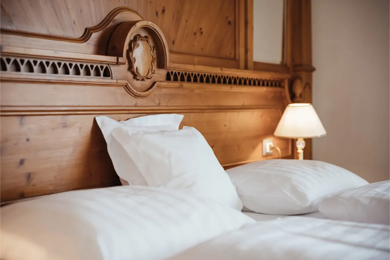 Hotel Corona in San Vigilio di Marebbe – Gemütliches Doppelbett mit Holzkopfteil | Wellnesshotel Dolomiten