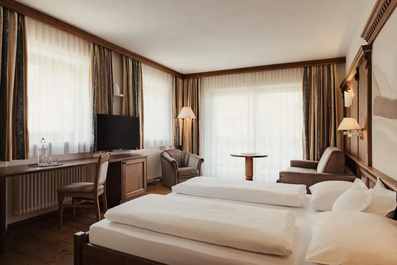 Hotel Corona in San Vigilio di Marebbe – Komfortables Doppelzimmer mit Schreibtisch und Sitzbereich | Wellnesshotel Dolomiten