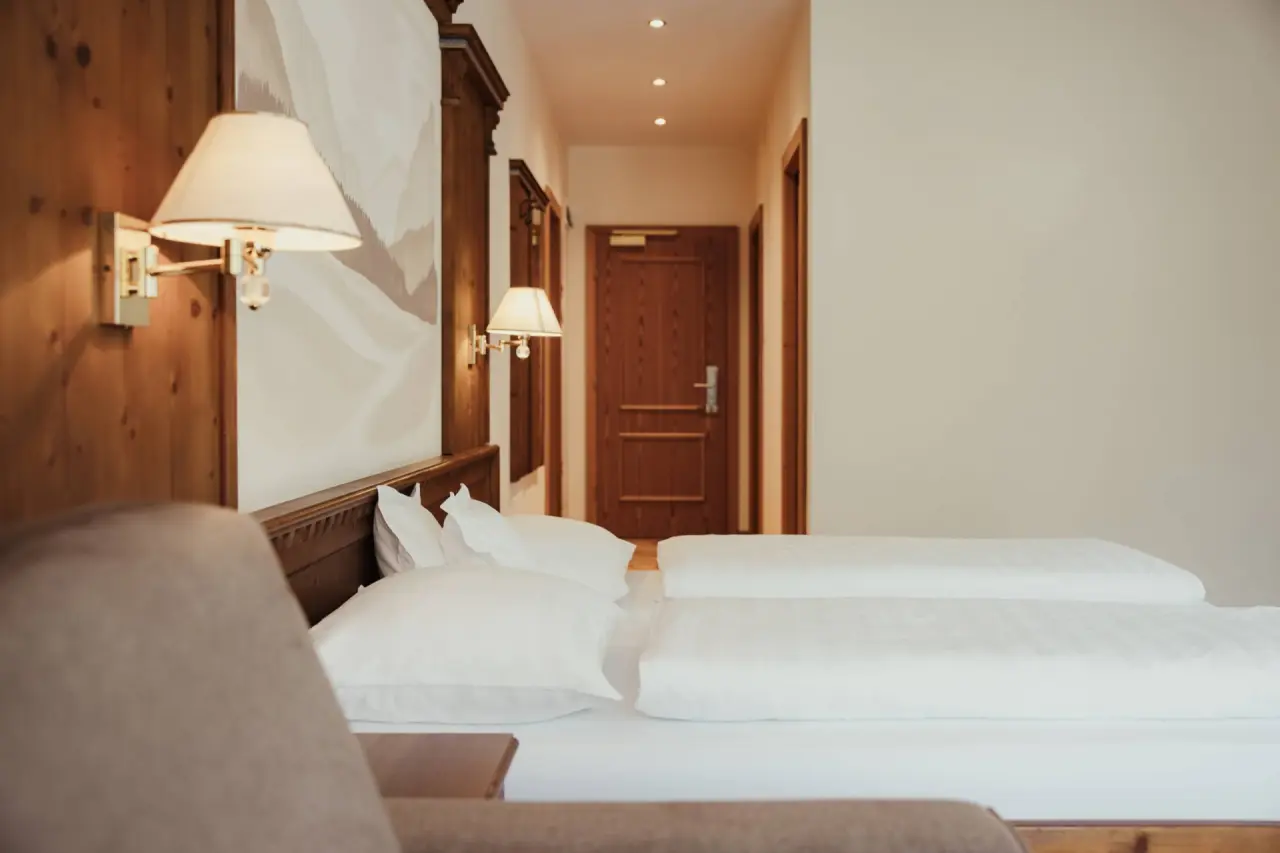 Hotel Corona in San Vigilio di Marebbe – Detailansicht eines Hotelbettes mit Zugang zum Flur | Wellnesshotel Dolomiten