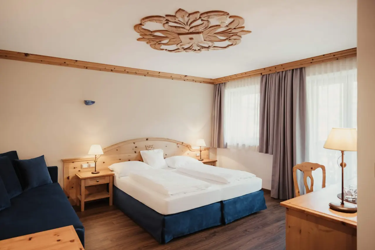 Hotel Corona in San Vigilio di Marebbe – Helles Hotelzimmer mit blauen Akzenten und Holzelementen | Wellnesshotel Dolomiten