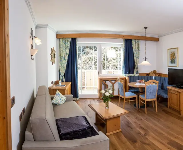 ANDREUS Golf & Spa Resort in Schenna – Geräumiger Wohnbereich mit Sitzecke und Balkon | Wellnesshotel Südtirol