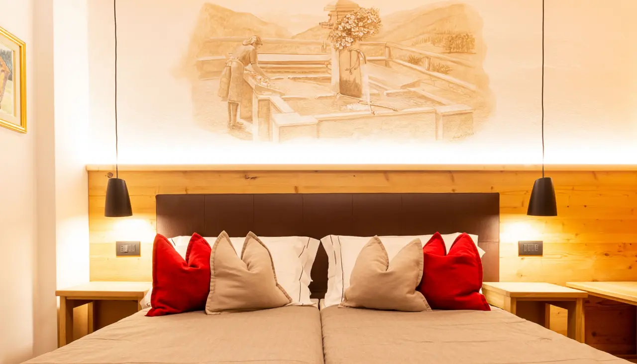 Hotel Santa Maria Swimming & Wellness in Pejo – Detailansicht eines Hotelbettes mit Wandmalerei | Wellnesshotel Trentino
