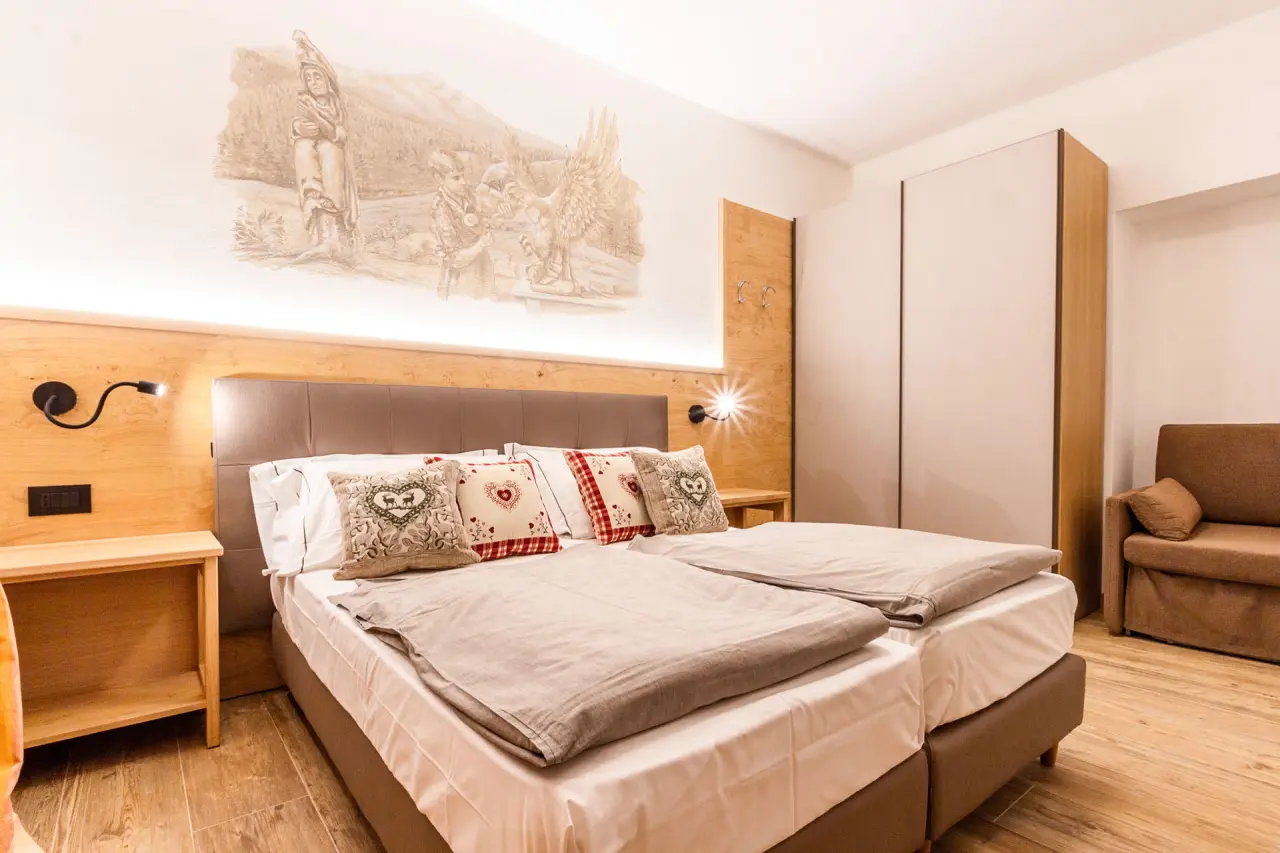 Hotel Santa Maria Swimming & Wellness in Pejo – Komfortables Hotelzimmer mit Holzbett und Sofa | Wellnesshotel Trentino