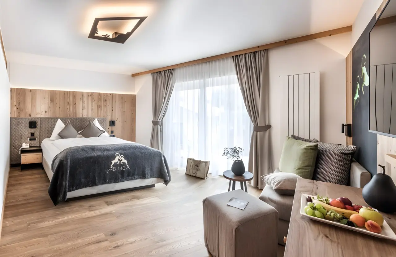 Abinea Dolomiti Romantic SPA Hotel in Kastelruth – Helles Doppelzimmer mit Sitzbereich und Obst | Wellnesshotel Südtirol