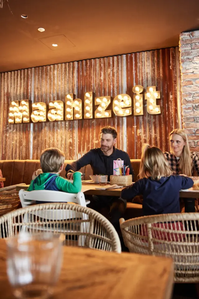 Familienhotel EdeR FriDa in Maria Alm – Familie beim Essen im Restaurantbereich | Wellnesshotel Salzburg