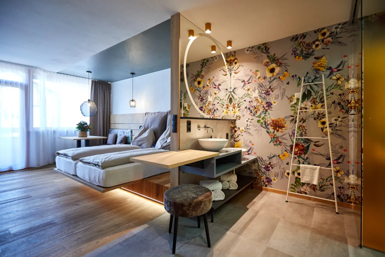 Familienhotel EdeR FriDa in Maria Alm – Modernes Hotelzimmer mit floraler Tapete und Doppelbett | Wellnesshotel Salzburg