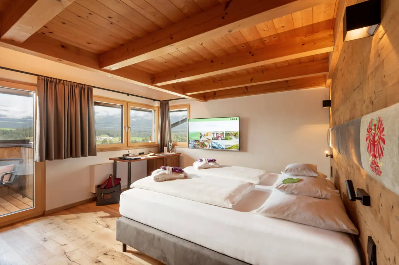 Hotel Penzinghof in Oberndorf in Tirol – Helles Doppelzimmer mit Holzbalken und Panoramafenstern | Wellnesshotel Tirol