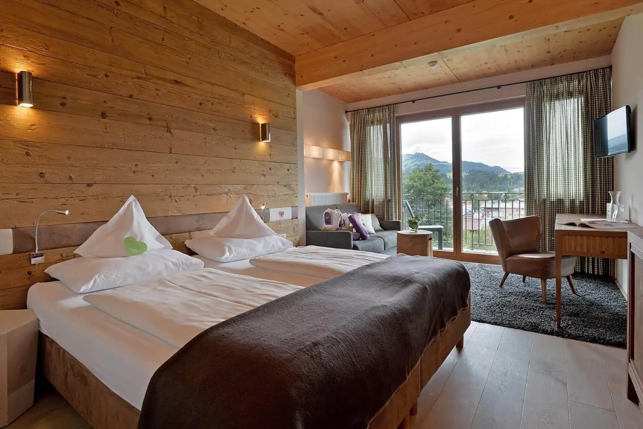 Hotel Penzinghof in Oberndorf in Tirol – Geräumiges Doppelzimmer mit Sofa und Balkon | Wellnesshotel Tirol