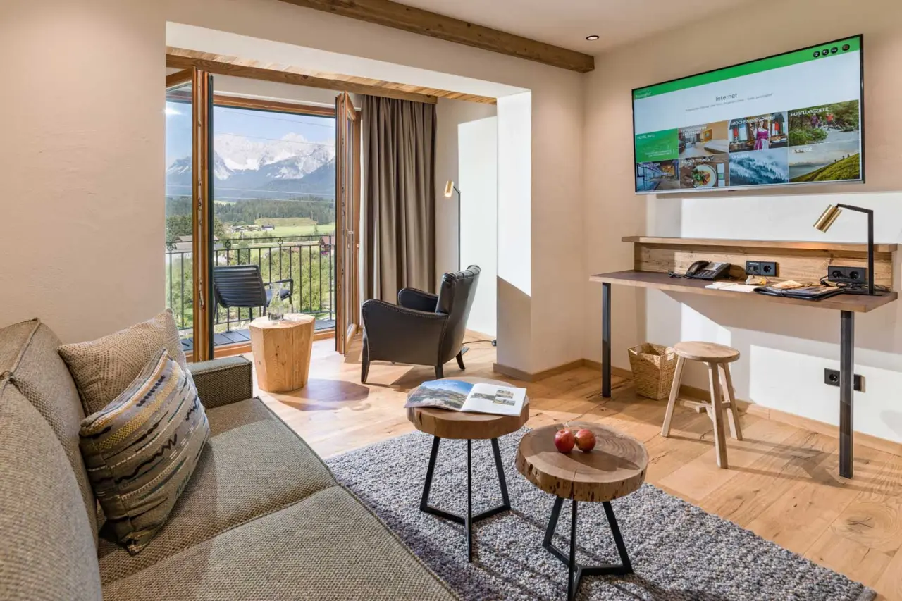 Hotel Penzinghof in Oberndorf in Tirol – Suite mit Wohnbereich und Bergblick vom Balkon | Wellnesshotel Tirol