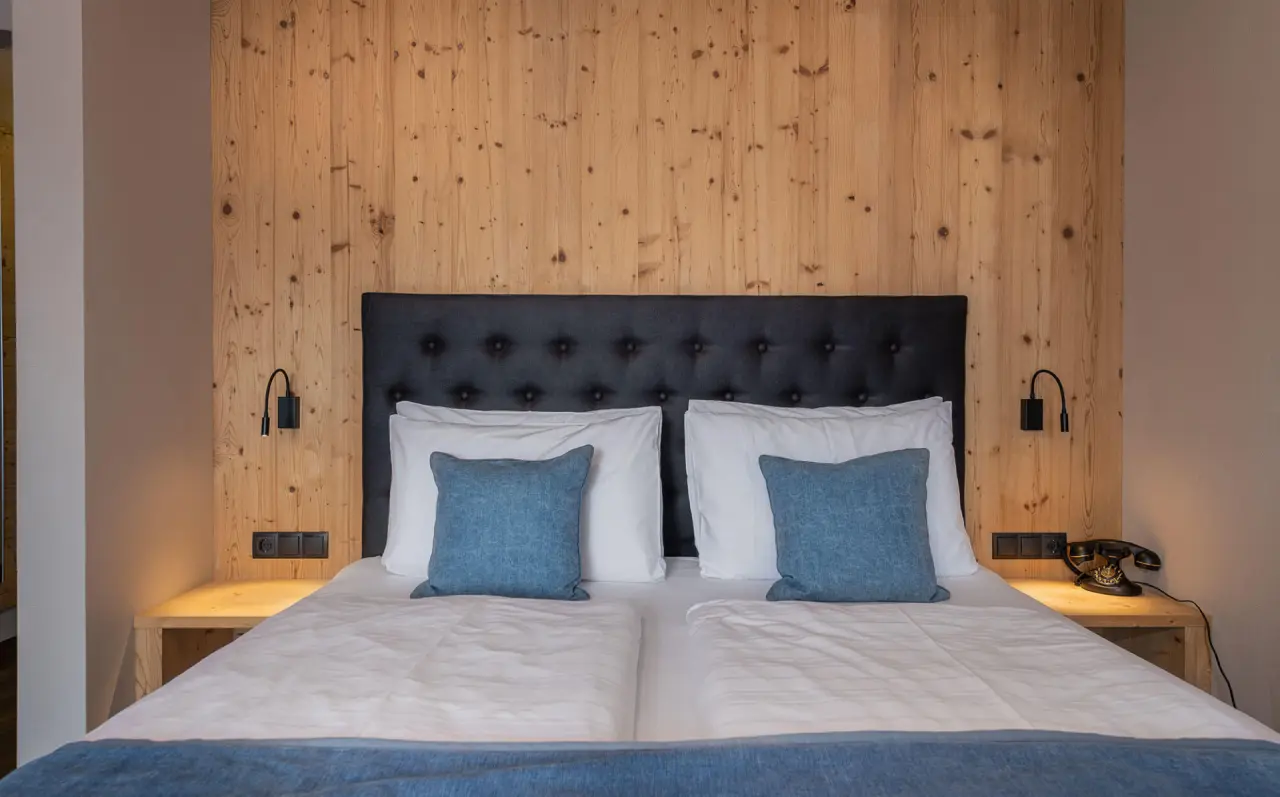 Hotel Tirolensis in Marling – Detailansicht des Bettes mit Holzkopfteil | Wellnesshotel Südtirol