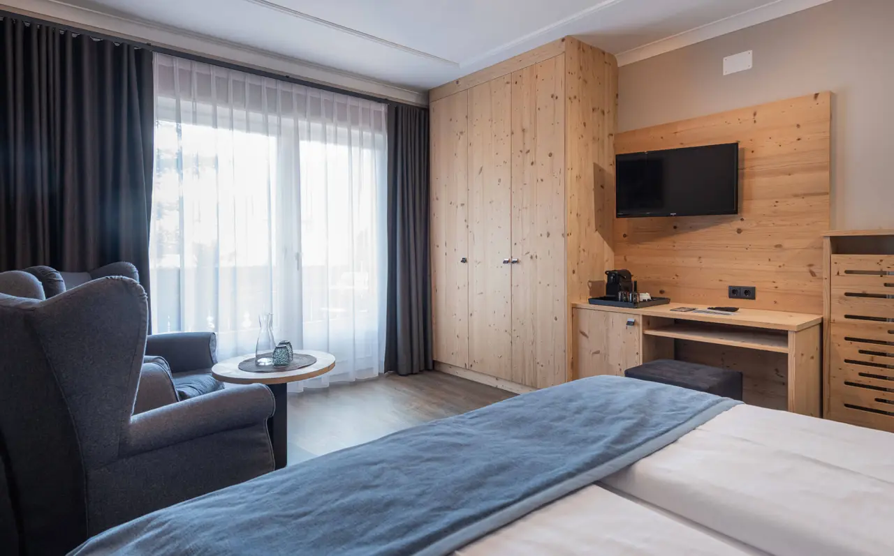 Hotel Tirolensis in Marling – Helles Doppelzimmer mit Holzmöbeln und Fenster | Wellnesshotel Südtirol