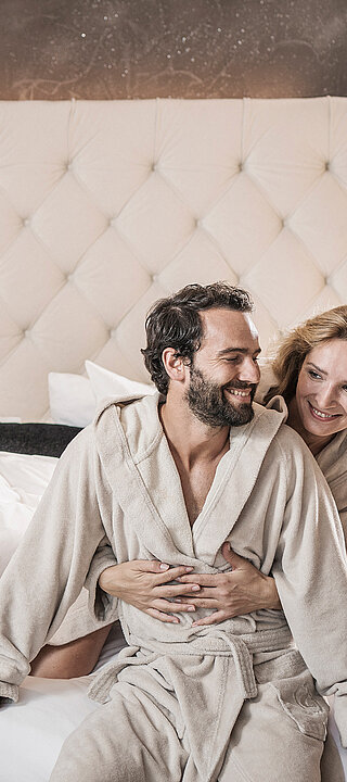 STOCK resort in Finkenberg – Glückliches Paar in Bademänteln entspannt im Hotelzimmer | Wellnesshotel Zillertal