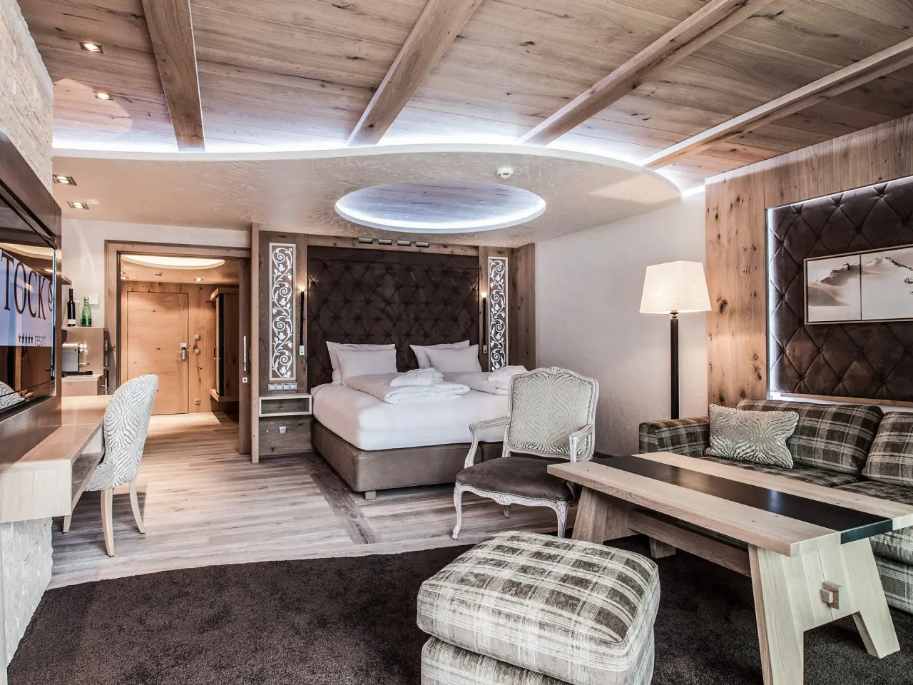 STOCK resort in Finkenberg – Geräumiges Hotelzimmer mit Holzelementen und Sitzbereich | Wellnesshotel Zillertal