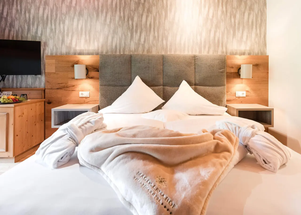 Hotel Magdalenahof in St. Martin in Gsies – Komfortables Doppelbett mit Bademänteln und Obstteller | Wellnesshotel Gsiesertal