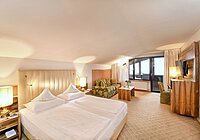 Hotel Hohenwart in Schenna – Helle Suite mit Doppelbett, Sofa und Balkonblick | Wellnesshotel Südtirol