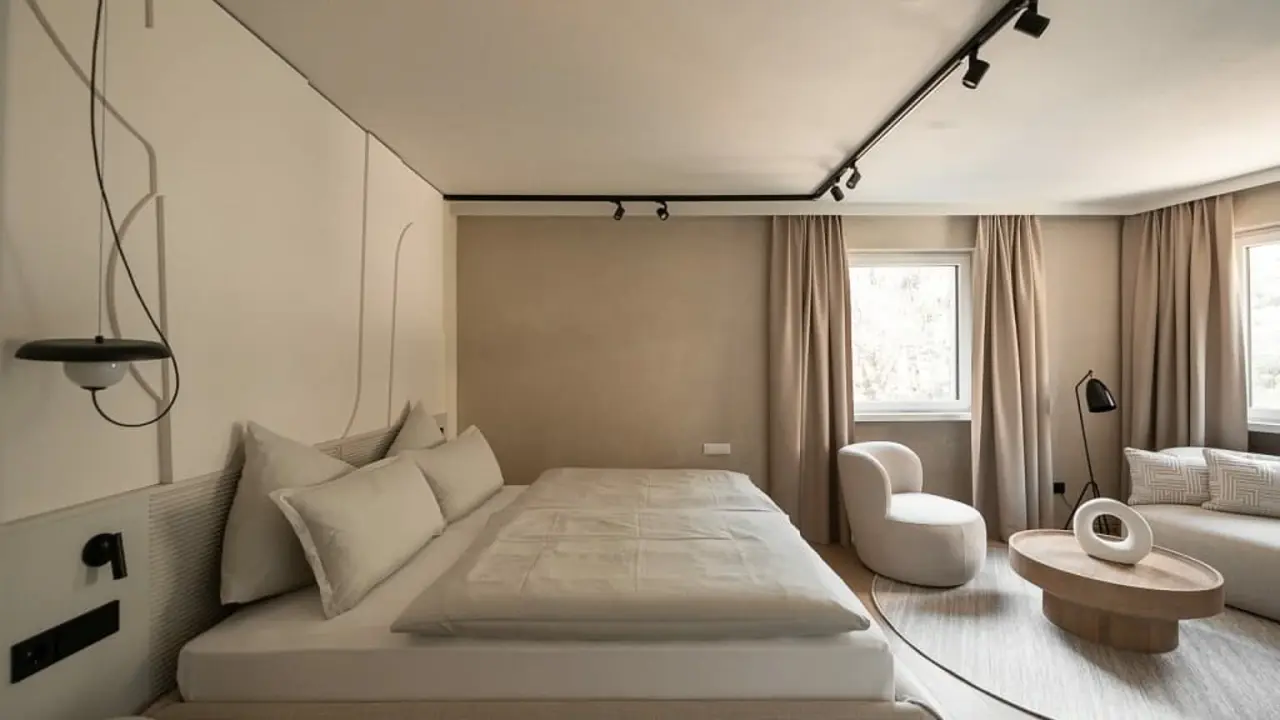 Sonnen Resort in Naturns – Modernes Schlafzimmer mit Doppelbett und gemütlicher Sitzecke | Wellnesshotel Südtirol