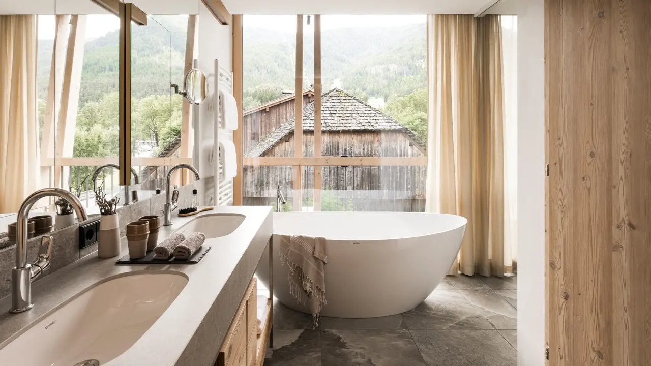 Falkensteiner Hotel Kronplatz in Bruneck – Luxuriöses Badezimmer mit freistehender Wanne und Bergblick | Wellnesshotel Südtirol