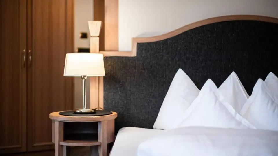 Hotel Gnollhof in St. Ulrich in Gröden – Nachttisch mit Leselampe im gemütlichen Hotelzimmer | Wellnesshotel Südtirol