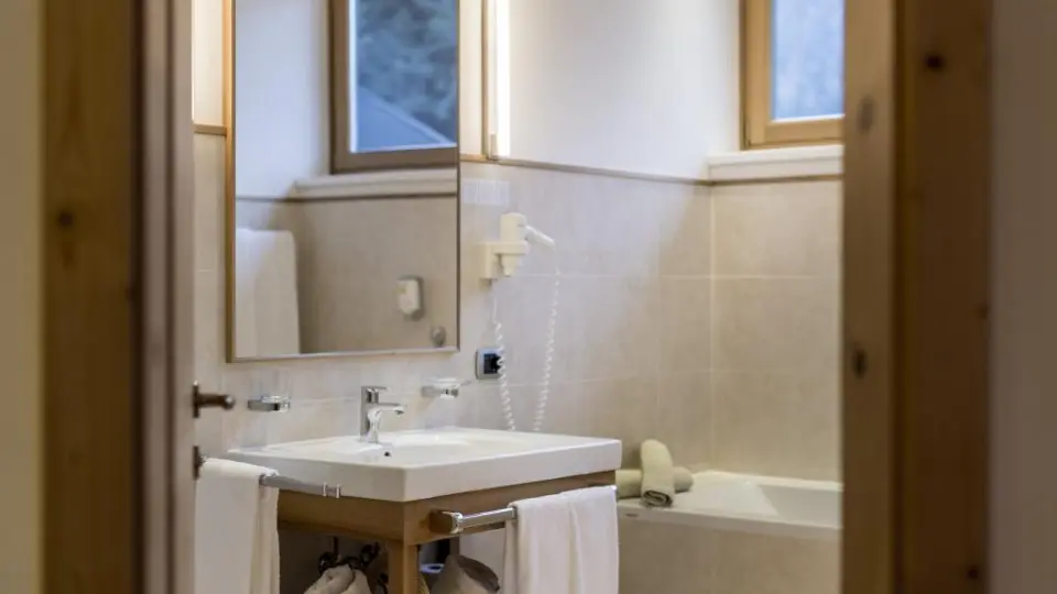 Hotel Gnollhof in St. Ulrich in Gröden – Helles Badezimmer mit Badewanne und Waschtisch | Wellnesshotel Südtirol