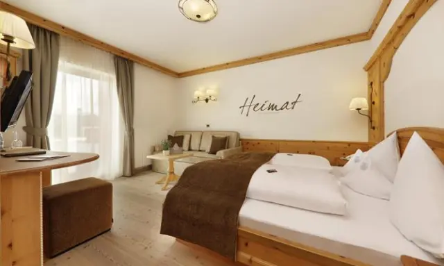 Hotel Plunhof in Ridnaun – Helles Doppelzimmer mit Sitzbereich und Balkonblick | Wellnesshotel Südtirol