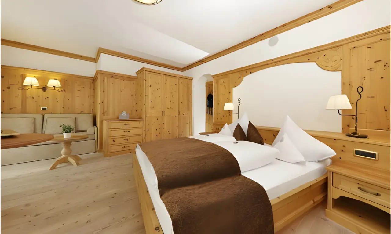 Hotel Plunhof in Ridnaun – Traditionelles Doppelzimmer mit Holzmöbeln und Sofa | Wellnesshotel Südtirol