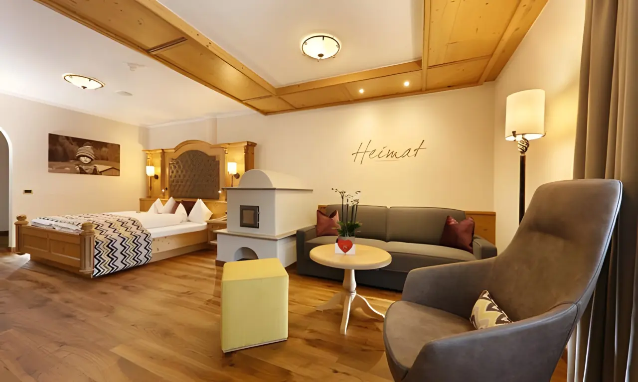 Hotel Plunhof in Ridnaun – Geräumiges Hotelzimmer mit Kamin und gemütlicher Sitzecke | Wellnesshotel Alpen