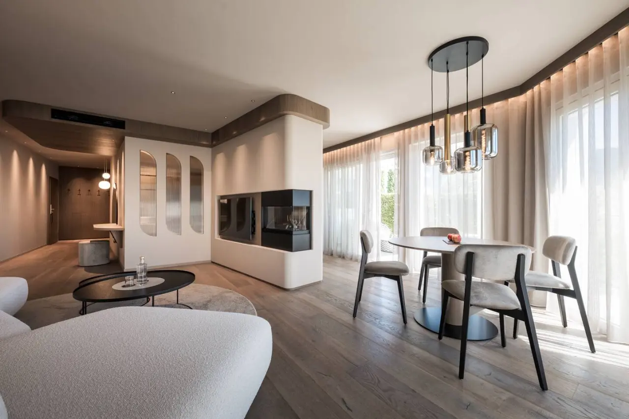 Small & Beautiful Hotel Gnaid in Dorf Tirol – Moderne Lounge mit Kamin und Essbereich | Wellnesshotel Südtirol