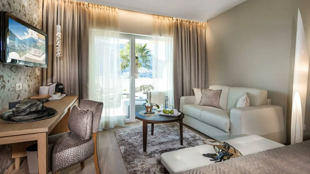 Small & Beautiful Hotel Gnaid in Dorf Tirol – Komfortables Zimmer mit Sofa und Balkonzugang | Wellnesshotel Südtirol