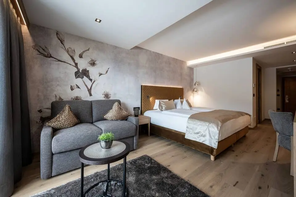 Small & Beautiful Hotel Gnaid in Dorf Tirol – Modernes Doppelzimmer mit Sofa und Wandkunst | Wellnesshotel Südtirol