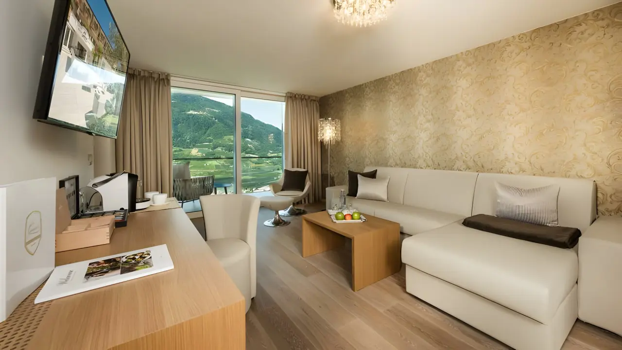 Small & Beautiful Hotel Gnaid in Dorf Tirol – Elegantes Zimmer mit Sofa und Panoramablick | Wellnesshotel Südtirol
