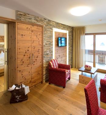 Hotel Wiesnerhof in Terenten – Gemütlicher Wohnbereich einer Suite mit Steinwand | Wellnesshotel Südtirol