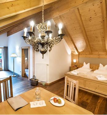 Hotel Wiesnerhof in Terenten – Rustikales Dachzimmer mit Holzbalken und Esstisch | Wellnesshotel Südtirol