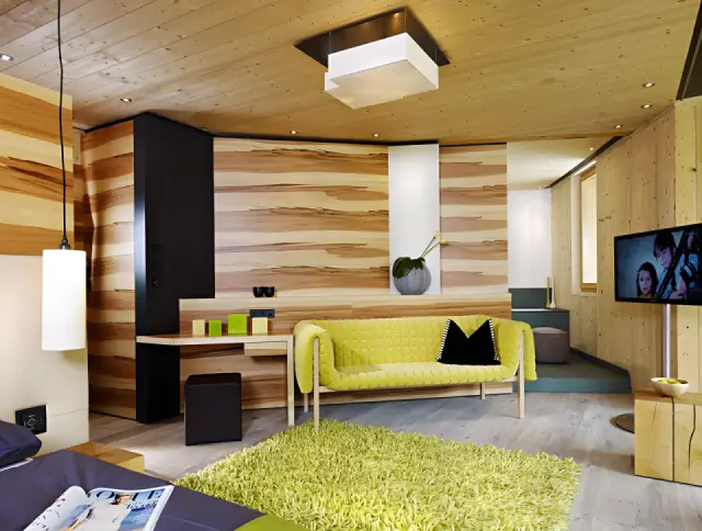 Naturhotel Waldklause in Längenfeld – Modernes Hotelzimmer mit Holzwänden und Sitzbereich | Wellnesshotel Tirol