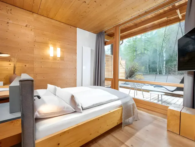 Naturhotel Waldklause in Längenfeld – Helles Hotelzimmer mit großem Fenster und Naturblick | Wellnesshotel Tirol