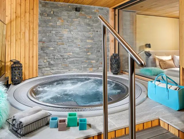 Naturhotel Waldklause in Längenfeld – Privater Whirlpool in einer Suite mit Steinwand | Wellnesshotel Ötztal