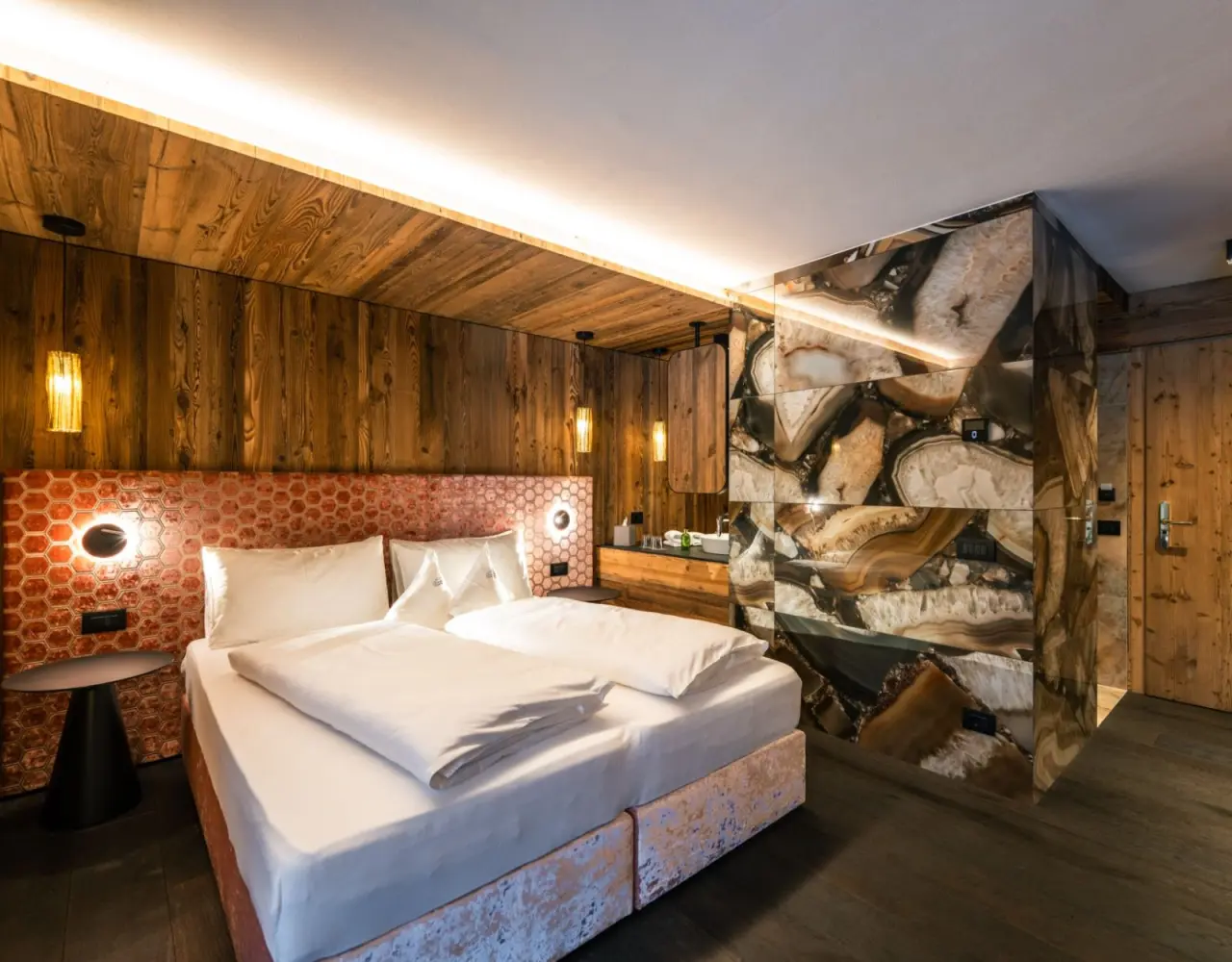 Hotel Christiania in La Villa – Modernes Doppelzimmer mit Holzelementen und Steinwand | Wellnesshotel Dolomiten