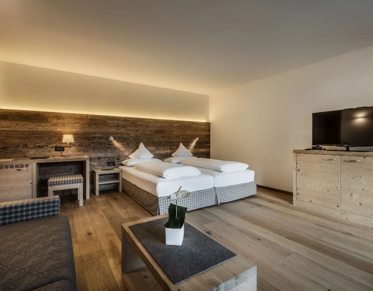 Hotel Christiania in La Villa – Helles Doppelzimmer mit Holzelementen und Sitzgelegenheit | Wellnesshotel Dolomiten